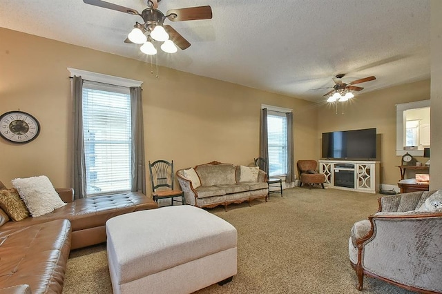 living area featuring a ceiling fan, carpet floors, and a textured ceiling