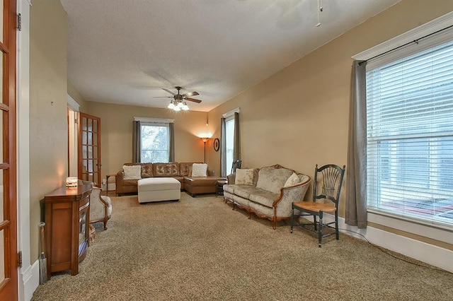 living area featuring a textured ceiling, ceiling fan, and carpet flooring