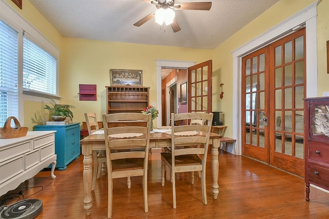 dining area with ceiling fan, a textured ceiling, and wood finished floors