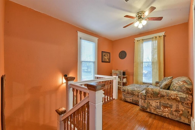 bedroom with multiple windows, ceiling fan, and hardwood / wood-style floors