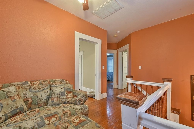 living area with hardwood / wood-style floors, baseboards, and visible vents