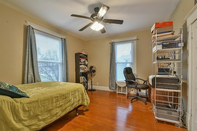 bedroom with wood finished floors, baseboards, and ceiling fan