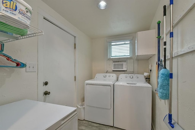 laundry area featuring cabinet space, an AC wall unit, and separate washer and dryer