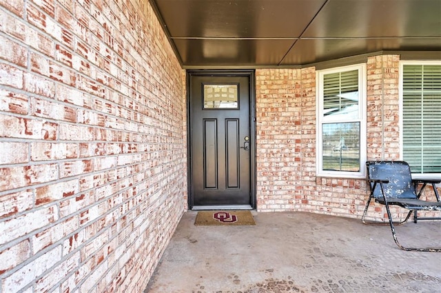 entrance to property featuring brick siding