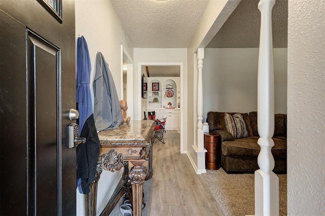 foyer entrance featuring wood finished floors and a textured ceiling