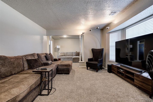 living area featuring visible vents, carpet floors, and a textured ceiling