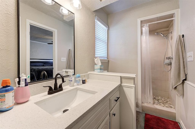 full bathroom featuring a shower stall, vanity, and a textured wall