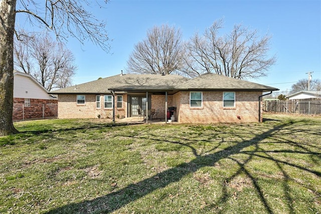 rear view of property featuring a yard, brick siding, fence private yard, and a patio area