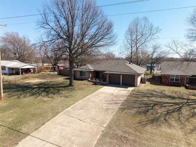 view of front facade with brick siding, fence, concrete driveway, a front yard, and an attached garage