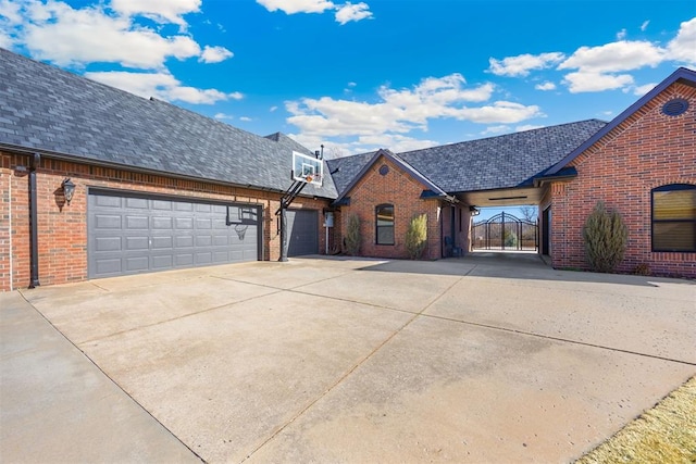 view of front of home with brick siding, driveway, a garage, and roof with shingles