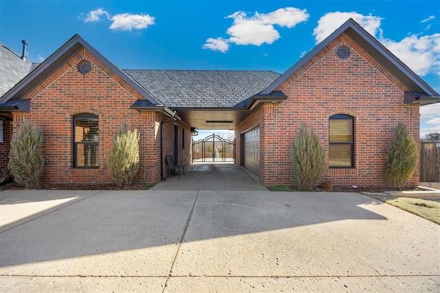 view of front facade featuring brick siding, driveway, an attached garage, and fence