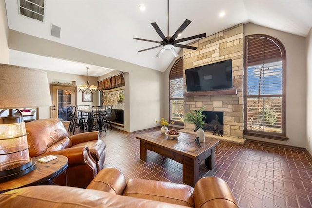 living area featuring visible vents, a fireplace, lofted ceiling, and brick floor