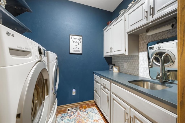 washroom with washer and clothes dryer, cabinet space, baseboards, and a sink