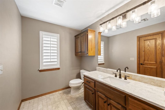 bathroom with visible vents, baseboards, toilet, tile patterned floors, and vanity