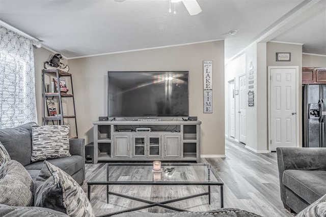 living room featuring baseboards, wood finished floors, a ceiling fan, and ornamental molding