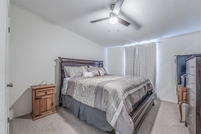 bedroom featuring a textured ceiling, lofted ceiling, a ceiling fan, and light carpet