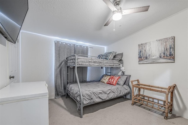 bedroom featuring carpet flooring, a textured ceiling, and a ceiling fan