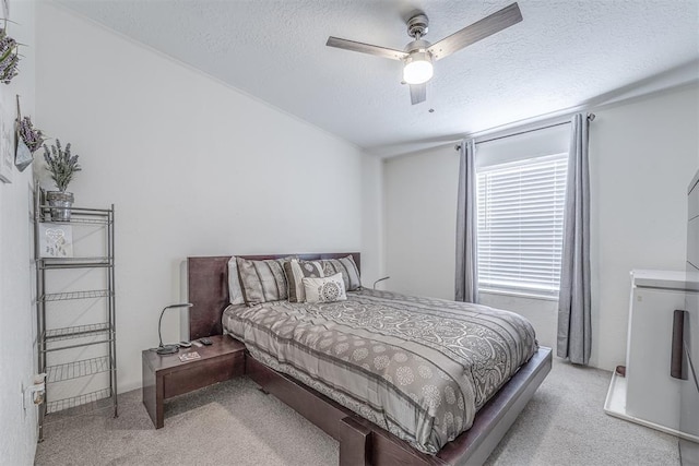 carpeted bedroom featuring a textured ceiling and a ceiling fan