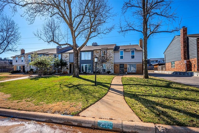 view of front facade with a residential view, brick siding, and a front lawn