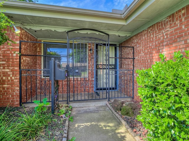 entrance to property featuring brick siding