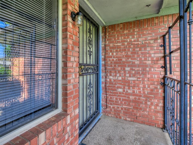 property entrance featuring brick siding