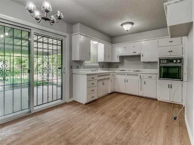 kitchen featuring light countertops, light wood-style flooring, white cooktop, and oven