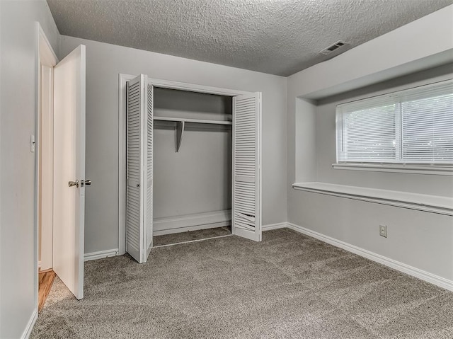 unfurnished bedroom with visible vents, baseboards, carpet floors, a closet, and a textured ceiling