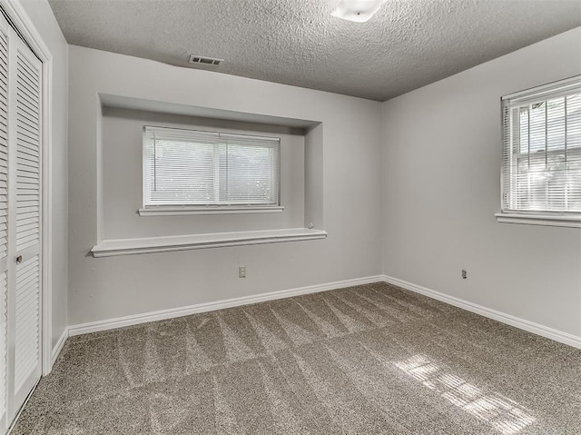 unfurnished bedroom featuring visible vents, baseboards, carpet floors, and a closet