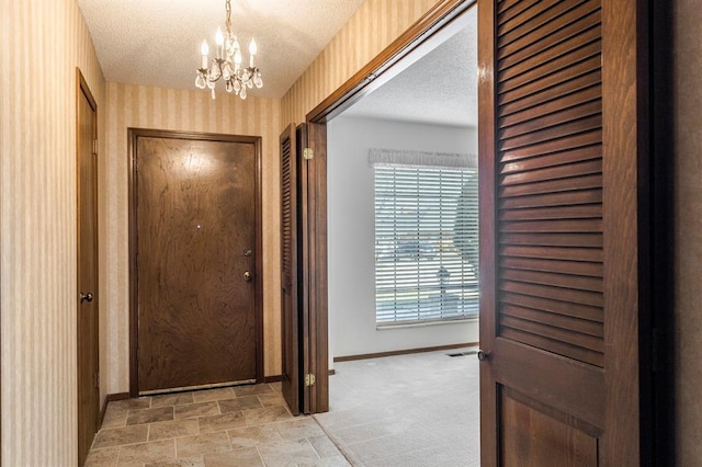 doorway to outside with wallpapered walls, baseboards, light colored carpet, an inviting chandelier, and a textured ceiling