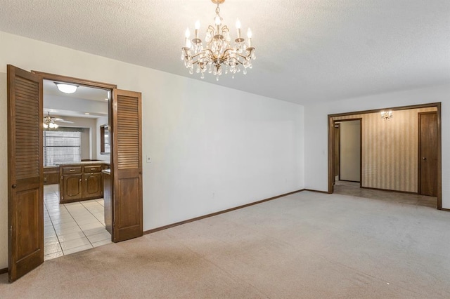 unfurnished room with light tile patterned floors, baseboards, a textured ceiling, light carpet, and ceiling fan with notable chandelier