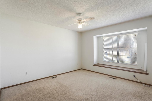 carpeted spare room with visible vents, baseboards, a textured ceiling, and ceiling fan