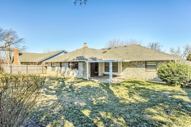 back of property featuring a patio area, brick siding, a lawn, and fence