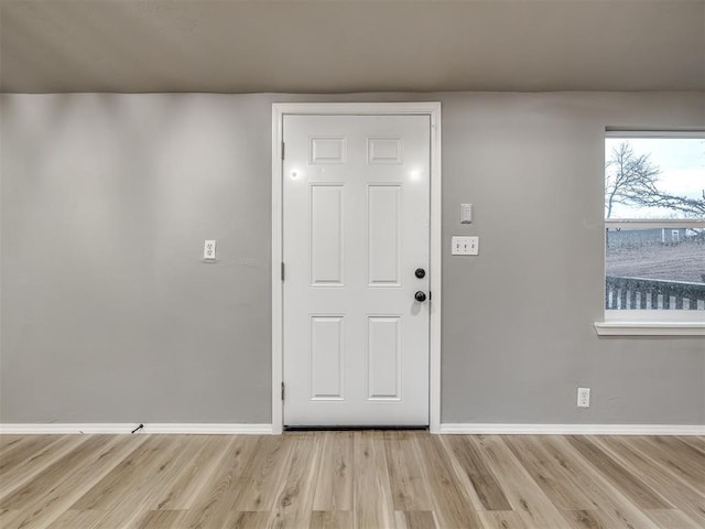 foyer entrance featuring baseboards and wood finished floors