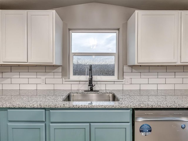 kitchen featuring a sink, decorative backsplash, dishwasher, and white cabinetry