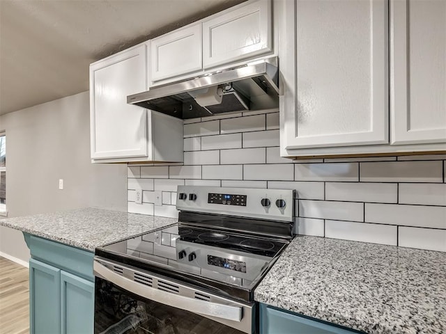 kitchen featuring tasteful backsplash, under cabinet range hood, stainless steel electric range, white cabinetry, and blue cabinets