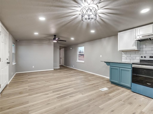 kitchen featuring backsplash, blue cabinetry, under cabinet range hood, light wood-style flooring, and electric range