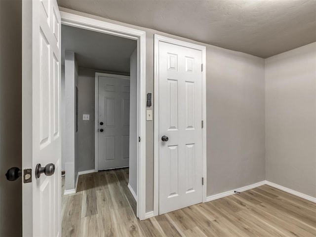 hallway with light wood-style floors and baseboards