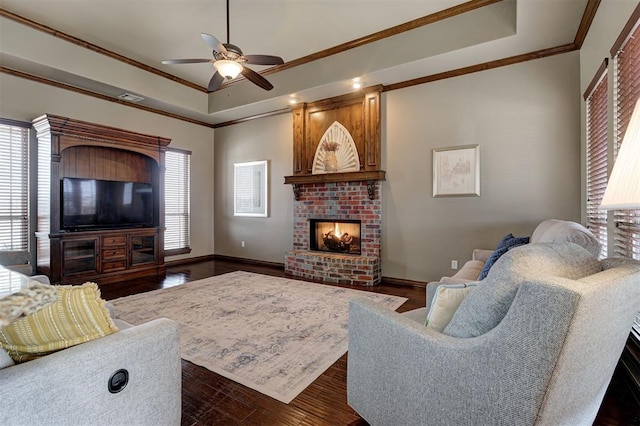 living area with visible vents, a raised ceiling, ceiling fan, and ornamental molding