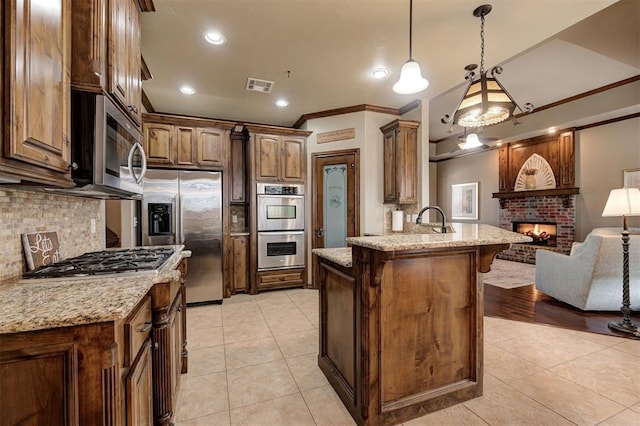 kitchen featuring visible vents, a brick fireplace, open floor plan, appliances with stainless steel finishes, and light tile patterned flooring