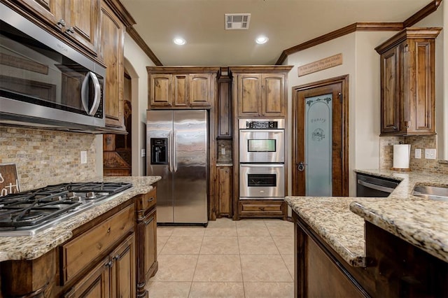 kitchen with visible vents, crown molding, light stone counters, appliances with stainless steel finishes, and light tile patterned flooring