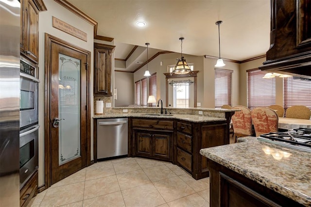 kitchen featuring a sink, stainless steel appliances, a peninsula, and ornamental molding