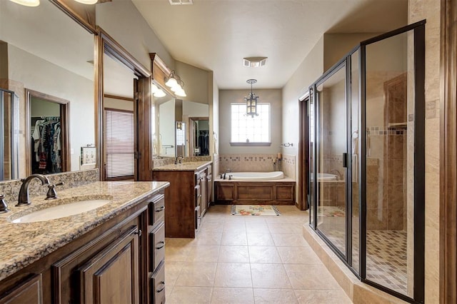 full bathroom featuring visible vents, a sink, a shower stall, a garden tub, and tile patterned floors