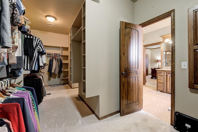 spacious closet featuring visible vents and light carpet