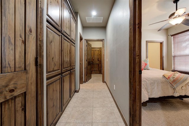 corridor featuring light tile patterned flooring, visible vents, and baseboards