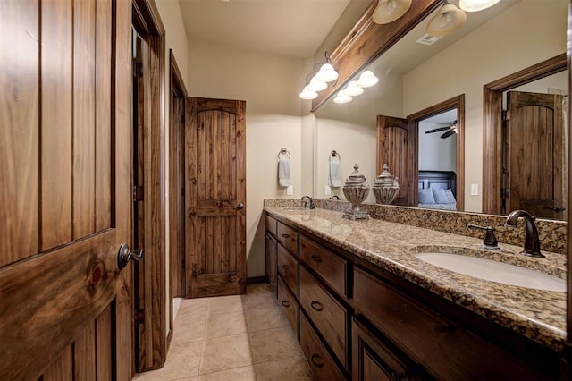 bathroom featuring tile patterned floors, double vanity, ensuite bathroom, and a sink