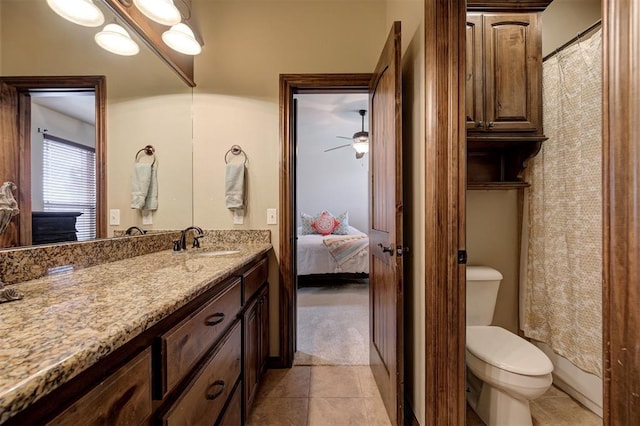 ensuite bathroom with tile patterned flooring, connected bathroom, toilet, vanity, and a ceiling fan