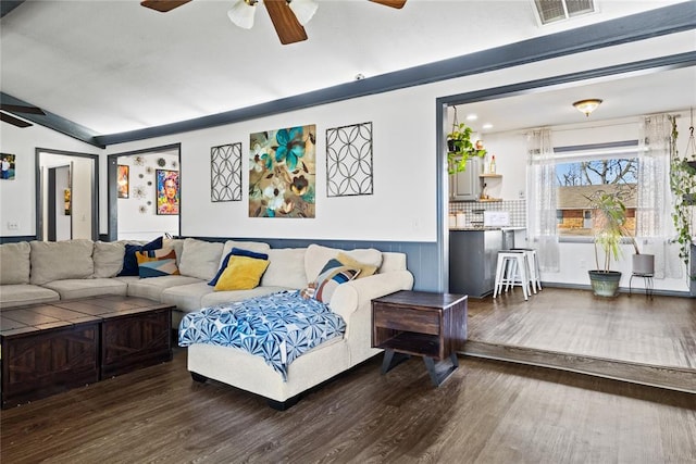 living area featuring ceiling fan, visible vents, wood finished floors, and vaulted ceiling