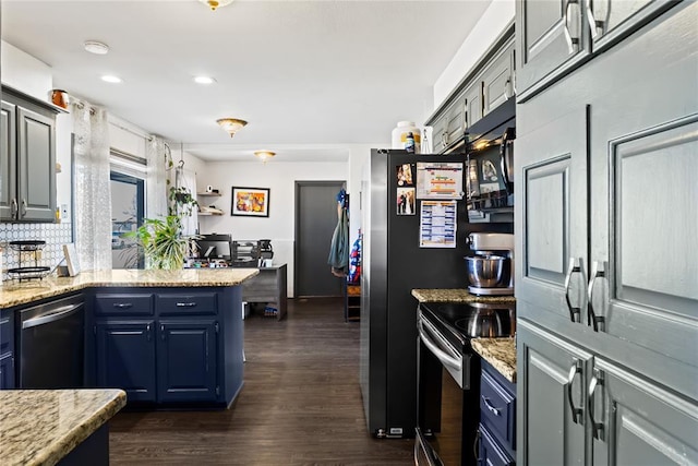 kitchen featuring blue cabinetry, light stone counters, appliances with stainless steel finishes, a peninsula, and dark wood-style floors