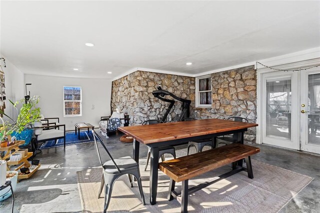 dining area with recessed lighting, french doors, concrete flooring, and a wood stove