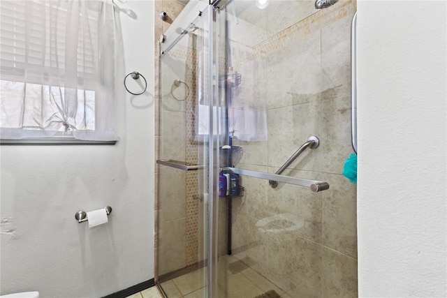 bathroom with toilet and a shower stall